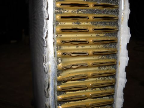 1986 Ford C-350 (Centurion Conversions) - The radiator fins are clogged with debris and show signs of corrosion and damage.