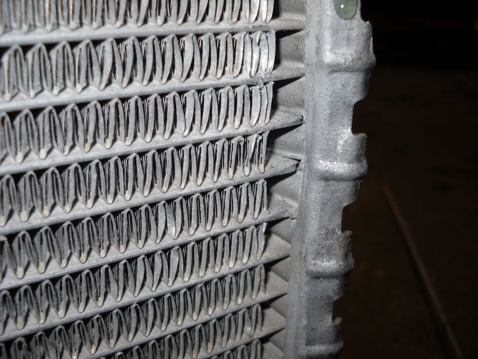 Close-up of a damaged radiator core with bent fins