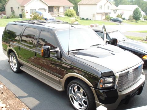 2000 Ford Excursion - A black 2000 Ford Excursion is parked in a driveway next to another vehicle.
