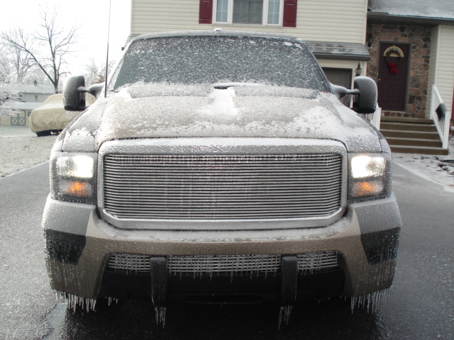 Front view of ice-covered Ford Excursion with billet grille and icicles hanging from bumper