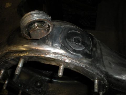 2009 Suzuki Samurai - Close-up of a metal axle housing component, showing a bolt and studs.