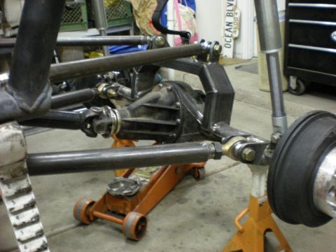 Suzuki Samurai - Custom multi-link suspension fabricated around a solid axle housing, with tubular upper and lower control arms ending in heim joints, a coi…