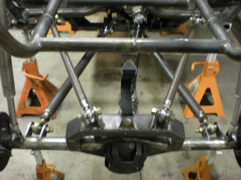 Suzuki Samurai - Rear underside of a custom tubular space-frame chassis with suspension links and a differential mount, supported on orange jack stands.
