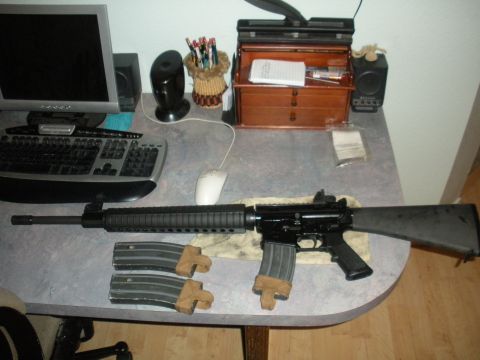 1996 Ford Bronco - A rifle and its magazines are displayed on a desk next to a computer setup.