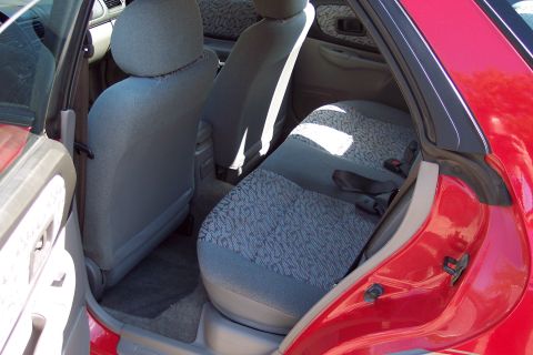 2001 Ford Crown Victoria - Rear interior view of a red car, showing the seats and seatbelts.