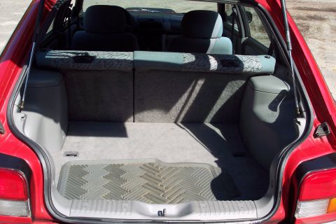 2001 Ford Crown Victoria - The interior of a car's trunk is visible, with a rubber mat on the floor and the rear seats folded down.