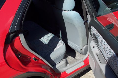 2001 Ford Crown Victoria - Interior view of a red car's rear passenger area, showing the seats and door panel.