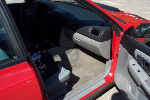 2001 Ford Crown Victoria - Interior view of a red car, focusing on the dashboard and passenger side.