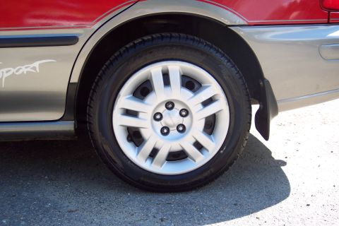 2001 Ford Crown Victoria - A close-up view of a car's wheel and lower body panel, showing a 'sport' decal.