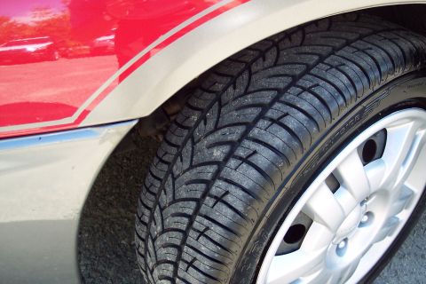 2001 Ford Crown Victoria - Close-up of a vehicle's tire and fender, showing a two-tone paint scheme.