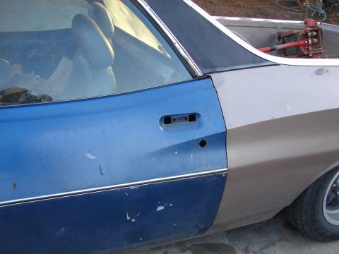1973 Ford Ranchero - The side of a Ford Ranchero shows a missing door handle and two-tone paint job.