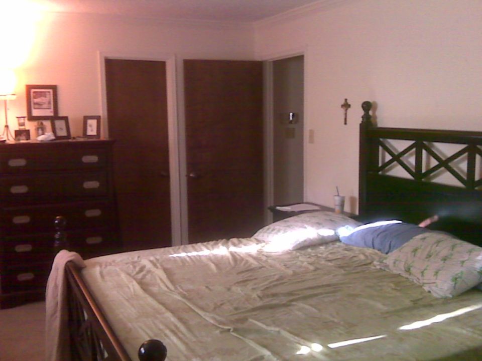 Bedroom with bed, dresser, and closet doors