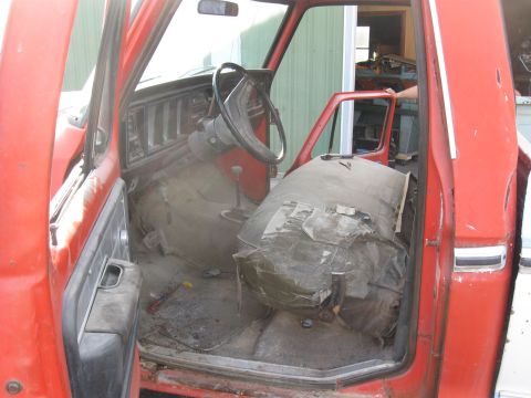 1979 Ford F-100 - Interior view of a red truck, revealing its aged seats and dashboard.