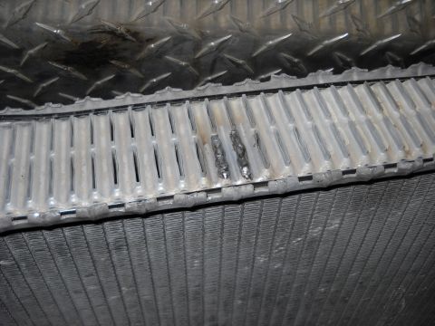 1986 Ford C-350 (Centurion Conversions) - The radiator shows signs of damage and repair, with visible weld marks on the upper section.