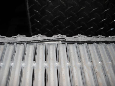 1986 Ford C-350 (Centurion Conversions) - Damaged radiator fins are visible against a black diamond plate surface.