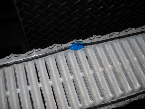 1986 Ford C-350 (Centurion Conversions) - A close-up view shows a radiator with a small amount of blue sealant applied to its top edge.