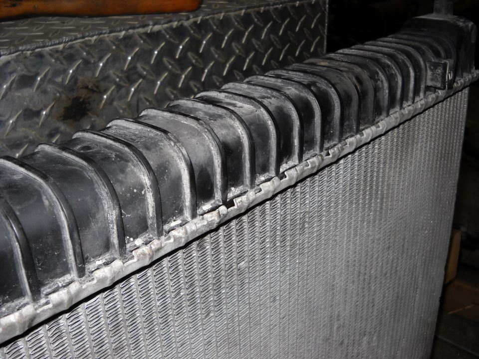 Close-up of a vehicle radiator with a black rubber top tank