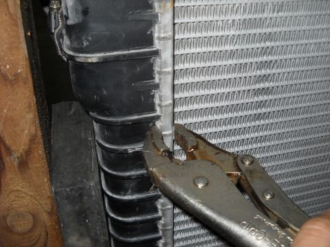 1986 Ford C-350 (Centurion Conversions) - Close-up of a radiator with vise grips attached to its side.