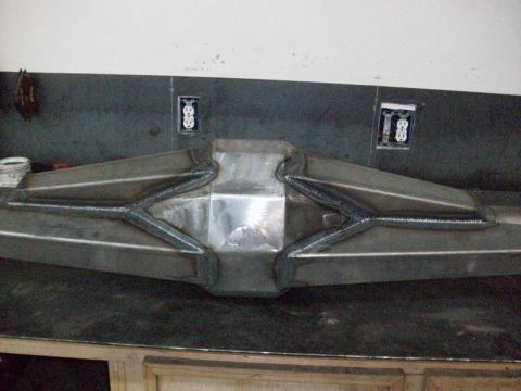 1996 Ford Bronco - A custom-made differential cover with a unique, reinforced design is shown on a workbench.