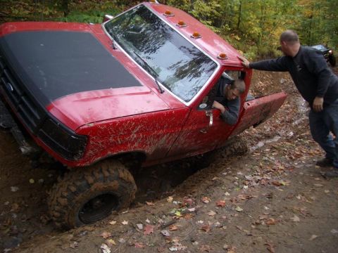1994 Ford F-250 - Red 1994 Ford F-250 stuck in mud, with assistance from another person and vehicle.