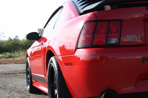 2004 Ford Mustang - Rear view of a red 2004 Ford Mustang Mach 1 showing the quarter panel and 'mach 1' badging.