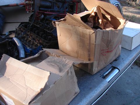 1973 Ford Ranchero - Cardboard boxes containing engine components are placed on the bed of a vehicle.