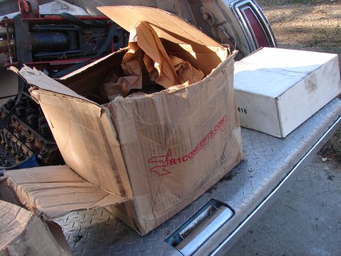 1973 Ford Ranchero - Cardboard boxes and engine parts are visible in the bed of a truck, with visible text on one of the boxes.