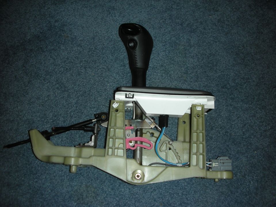 Automatic transmission shifter assembly with black shift knob and green plastic housing