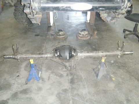 1978 Ford Bronco - A disassembled rear axle assembly is supported by jack stands in a garage setting.