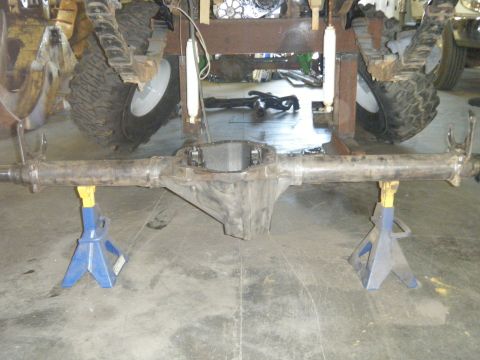 1978 Ford Bronco - Rear axle assembly supported by jack stands, showing suspension components and large tires.