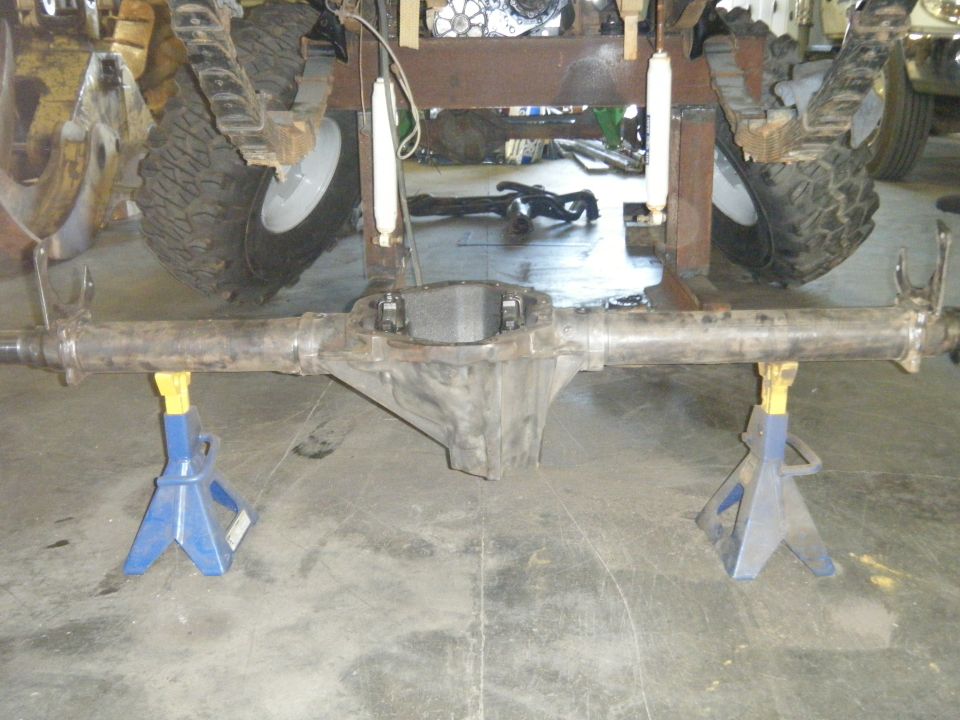 Rear axle assembly on jack stands, with visible suspension components and tires