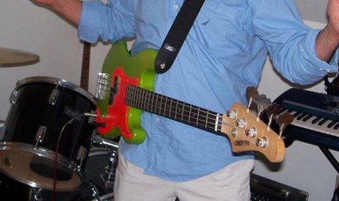1971 Ford Ranchero - A person plays a green and red bass guitar next to a drum set and a keyboard.