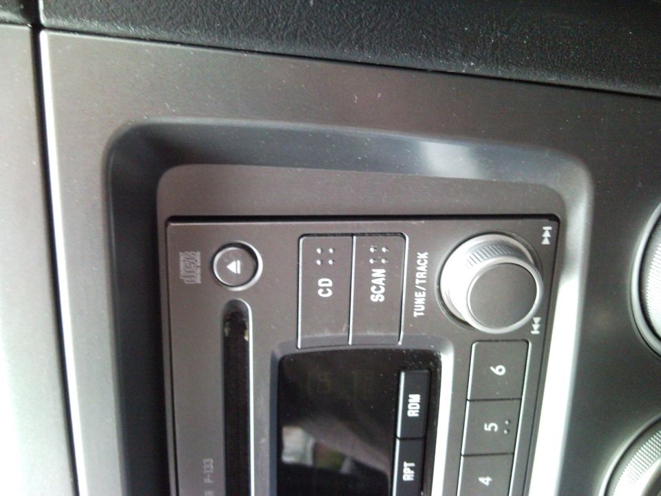 Close-up of a car stereo with buttons for CD, SCAN, TUNE/TRACK, and numbered presets