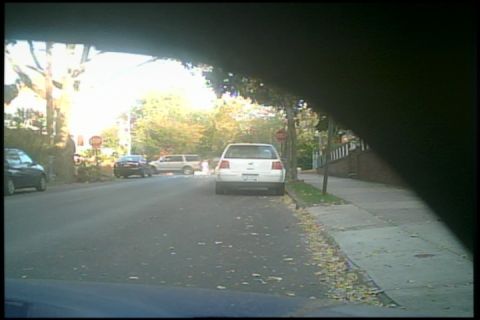 2007 Subaru Impreza - A white sedan is parked on the right side of a street lined with trees and sidewalks.