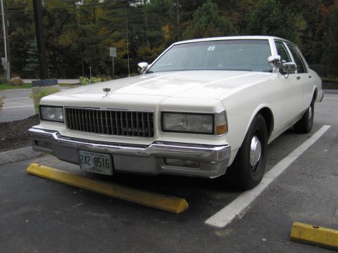 1991 Ford LTD Crown Victoria - This Chevrolet Caprice sedan, likely from the 1980s, is parked in a lot. The grille and headlights are characteristic of that era.