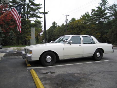 1991 Ford LTD Crown Victoria - This white sedan appears to be from the 1980s, not a 1991 Ford Crown Victoria LTD.