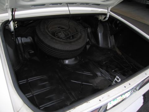 1991 Ford LTD Crown Victoria - The trunk of a car contains a spare tire and appears to be clean.