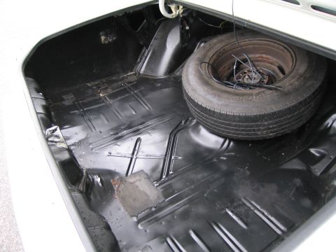 1991 Ford LTD Crown Victoria - The trunk interior shows a spare tire and a black floor with visible wear and some rust.