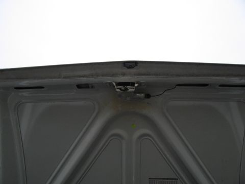 1991 Ford LTD Crown Victoria - Underside of a car hood, showing the latch mechanism and structural bracing.