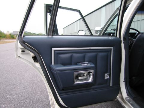 1991 Ford LTD Crown Victoria - Interior view of a car's driver side door panel with navy blue upholstery and chrome trim.