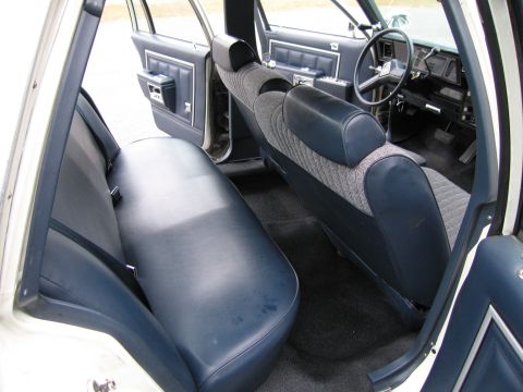 1991 Ford LTD Crown Victoria - The interior of this sedan features a bench seat in the rear and bucket seats in the front, with a dark dashboard and steering wheel.