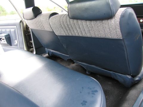 1991 Ford LTD Crown Victoria - Interior view of rear bench seats with blue vinyl and patterned fabric.