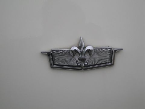 1991 Ford LTD Crown Victoria - A chrome emblem a fleur-de-lis design is attached to the vehicle's body.