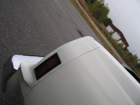 1991 Ford LTD Crown Victoria - Close-up of a white car's rear corner, showing chrome bumper and reflector.