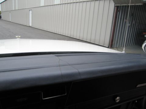 1991 Ford LTD Crown Victoria - Interior view shows a cracked dashboard and a hood ornament on the white hood.