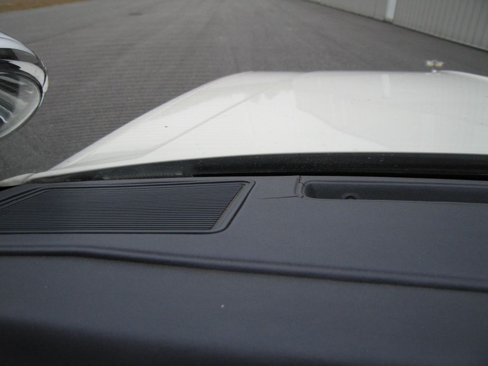 Dashboard speaker grille and cracked dashboard area of a car