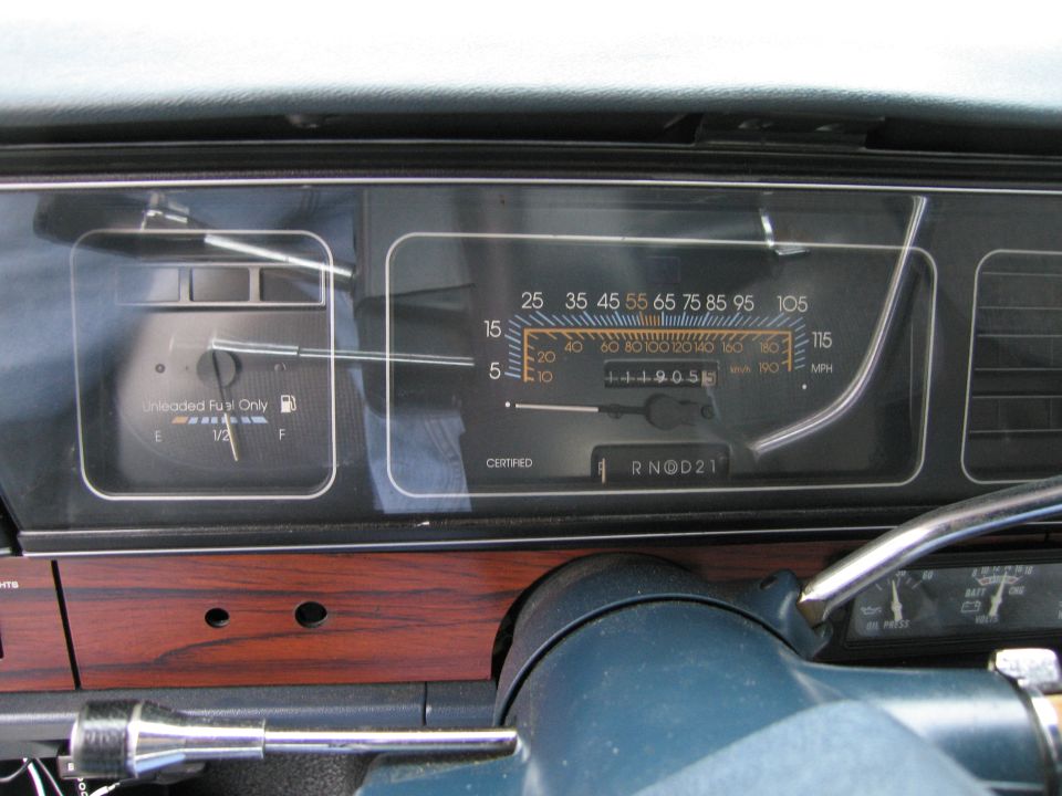 Car dashboard with fuel gauge and speedometer showing 44905 miles. Gear selector is in 'R' (Reverse)