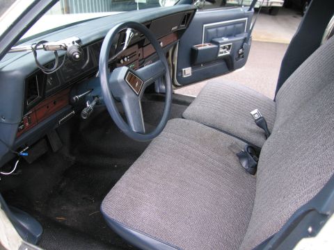 1991 Ford LTD Crown Victoria - The interior of this vehicle features a blue dashboard, steering wheel, and door panels, complemented by grey fabric seats and seatbelts.