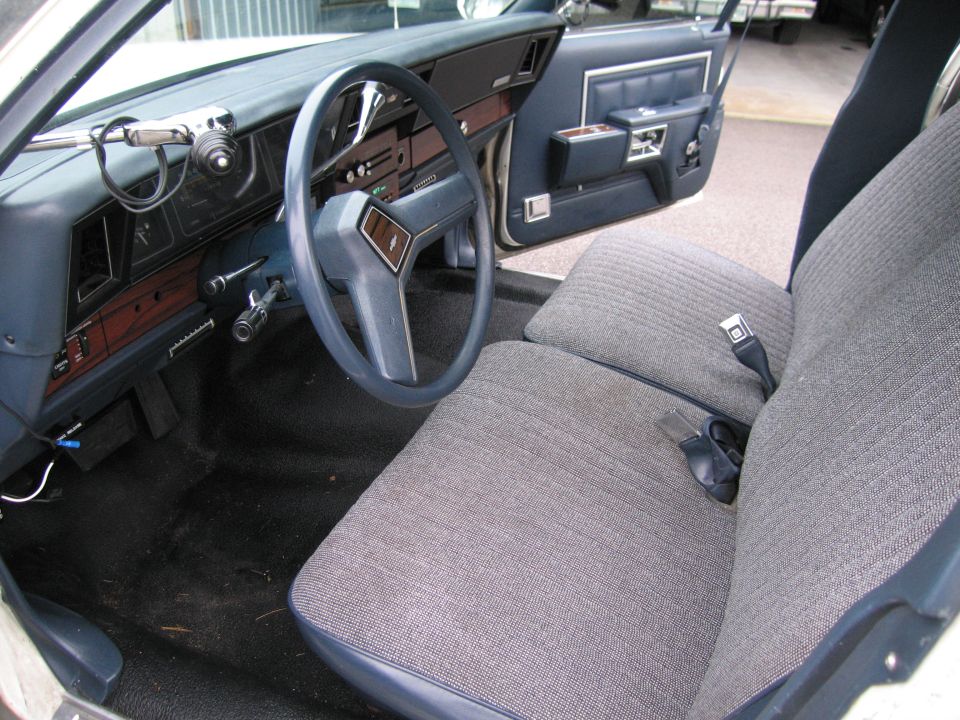 Interior view of a car with blue dashboard and grey fabric seats