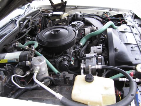 1991 Ford LTD Crown Victoria - The engine compartment of a vehicle, showing various components and wiring.